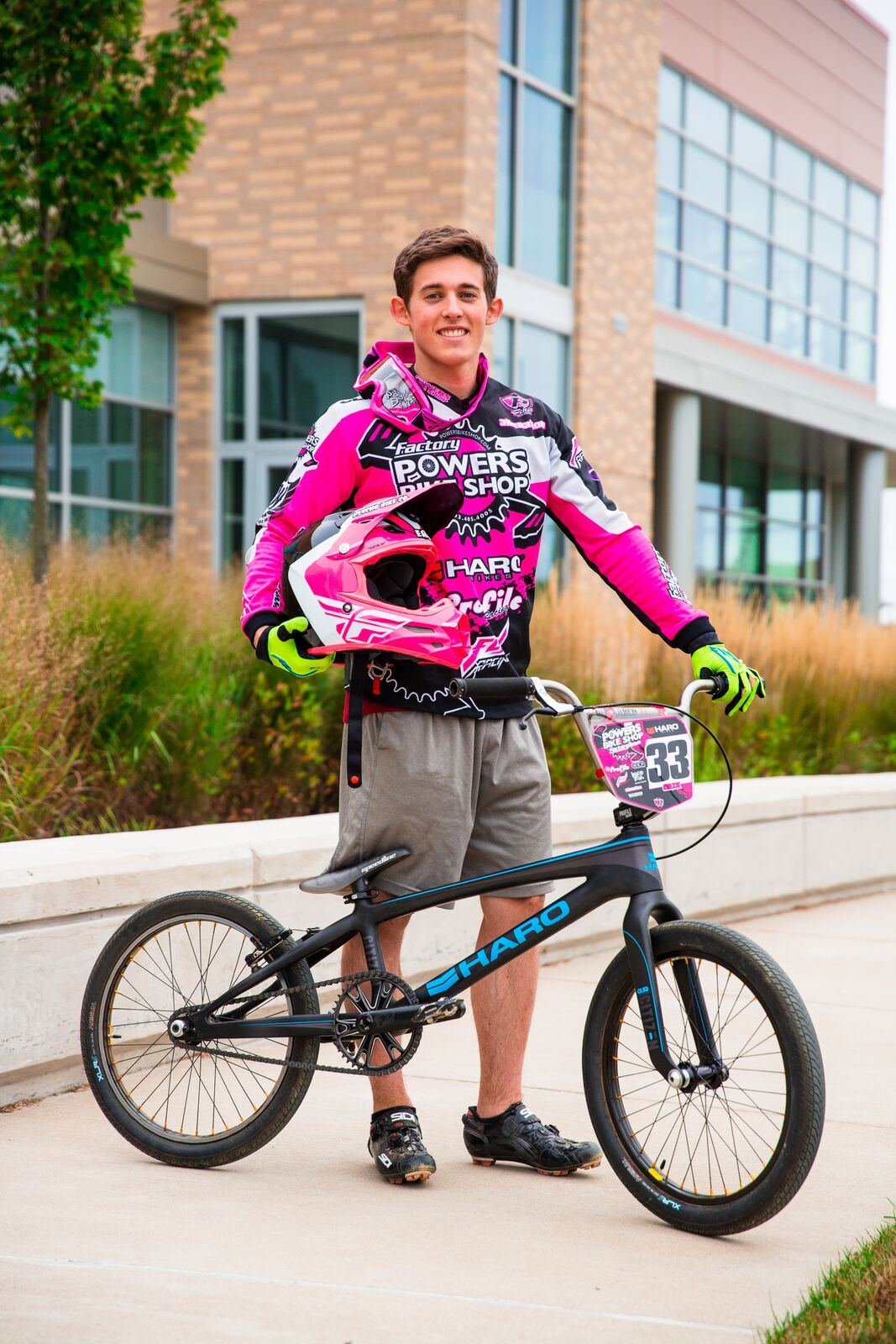 Photograph of student erik klein standing next to his BMX bike holding a helmet