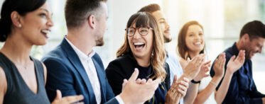 A photo of a group of businesspeople applauding during a seminar