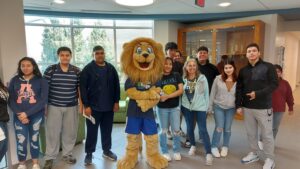 smiling students posing with mascot