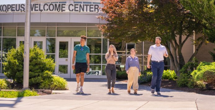 four people walking outside of the Laurel Ridge Community College middletown campus