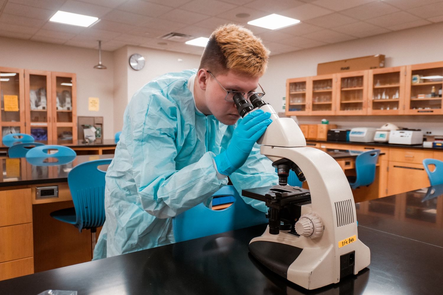 Henderson in science lab using microscope