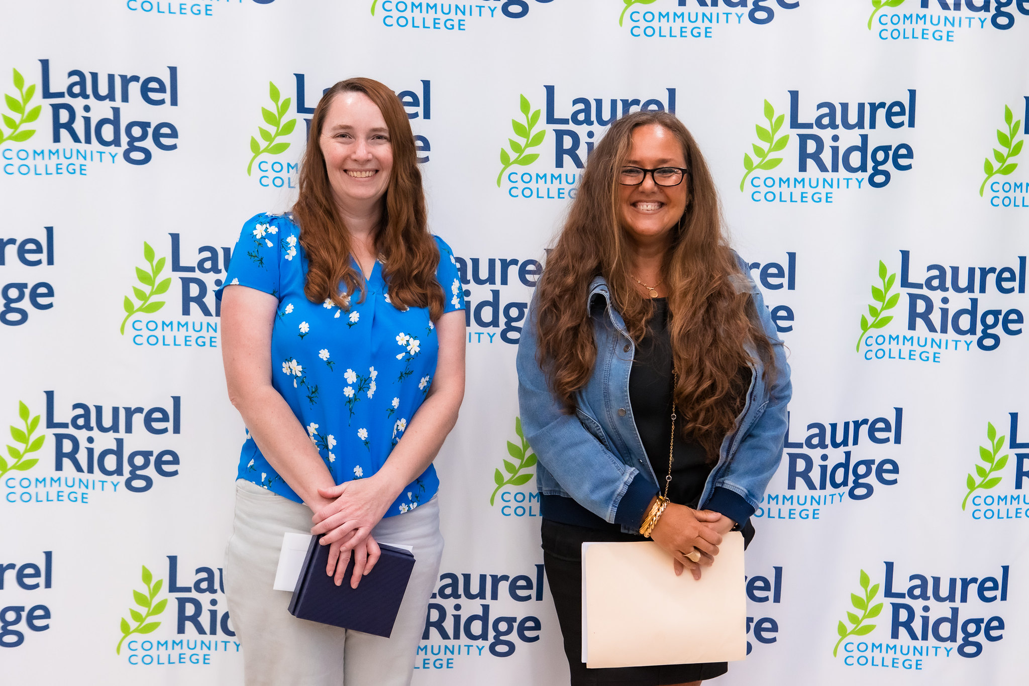 photo of two woman looking forwards at the camera and smiling