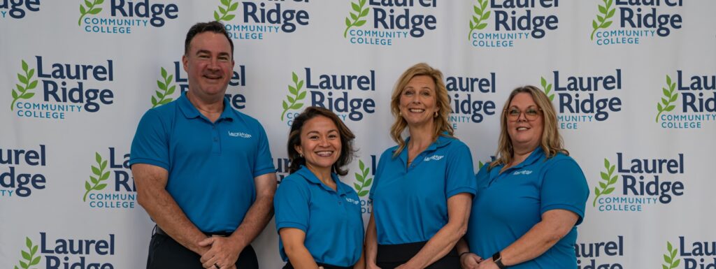 Photo of a group of four people facing forward and smiling