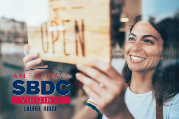 photo of a woman hanging an open sign at a business window
