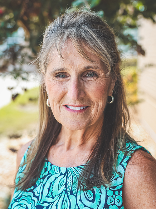 a headshot photograph of Joyce DUrso standing outside facing the camera