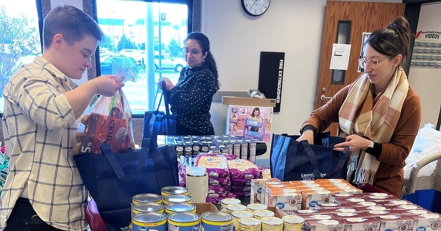 Meder works alongside student volunteers packing bags of nonperishable food in the campus food pantry