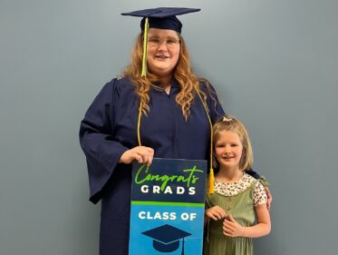 a photograph of a laurel ridge graduate in cap and gown standing next to her daughter