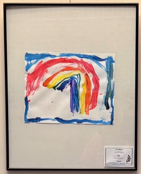 Artwork done by preschoolers hangs on the wall.