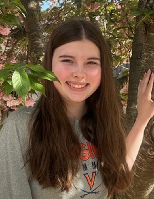 FEA student Eliza standing outdoors near a tree on campus.