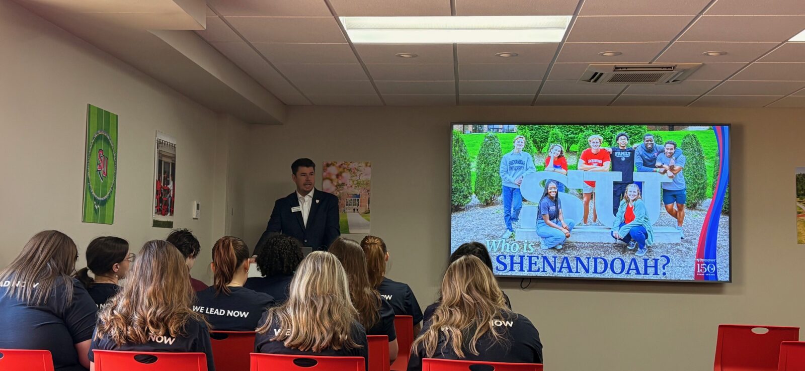 FEA students seated in a classroom listening attentively to the executive director of undergraduate recruitment discuss admissions information.