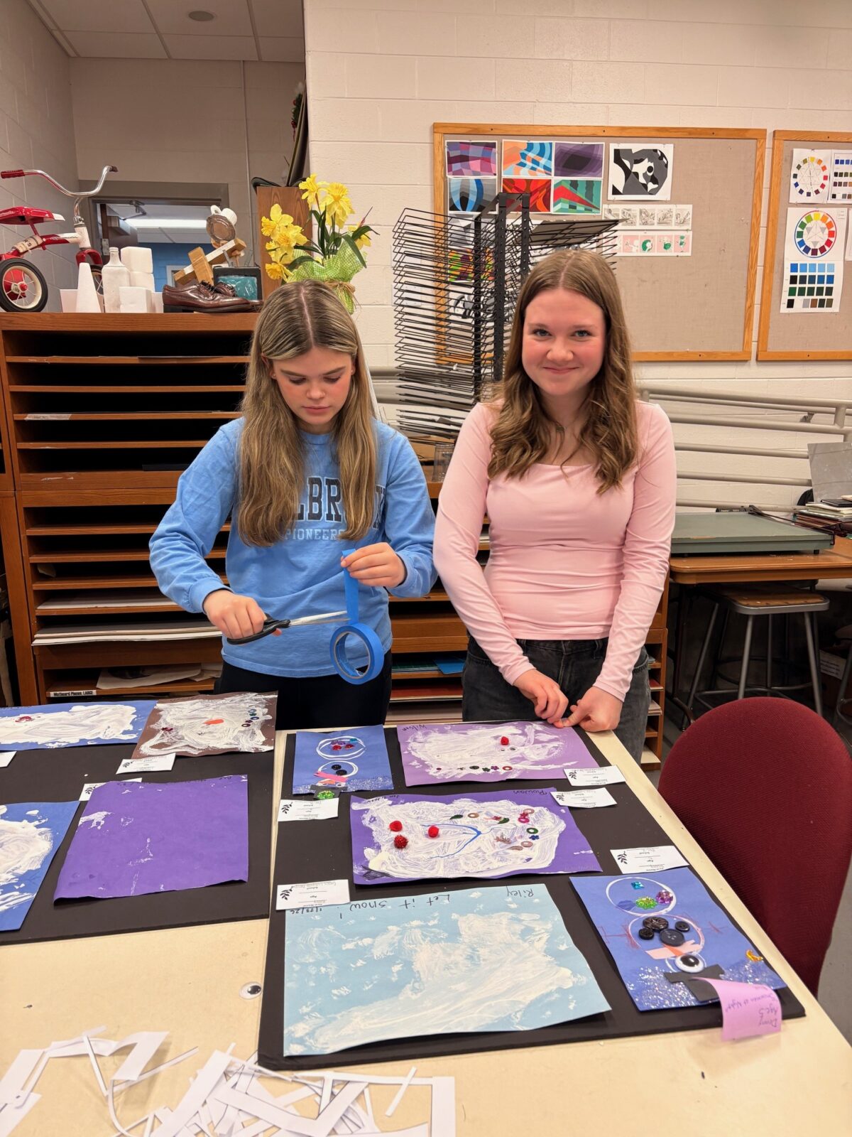 FEA students Sarah and Aliyah organizing and preparing artwork for display in the gallery.