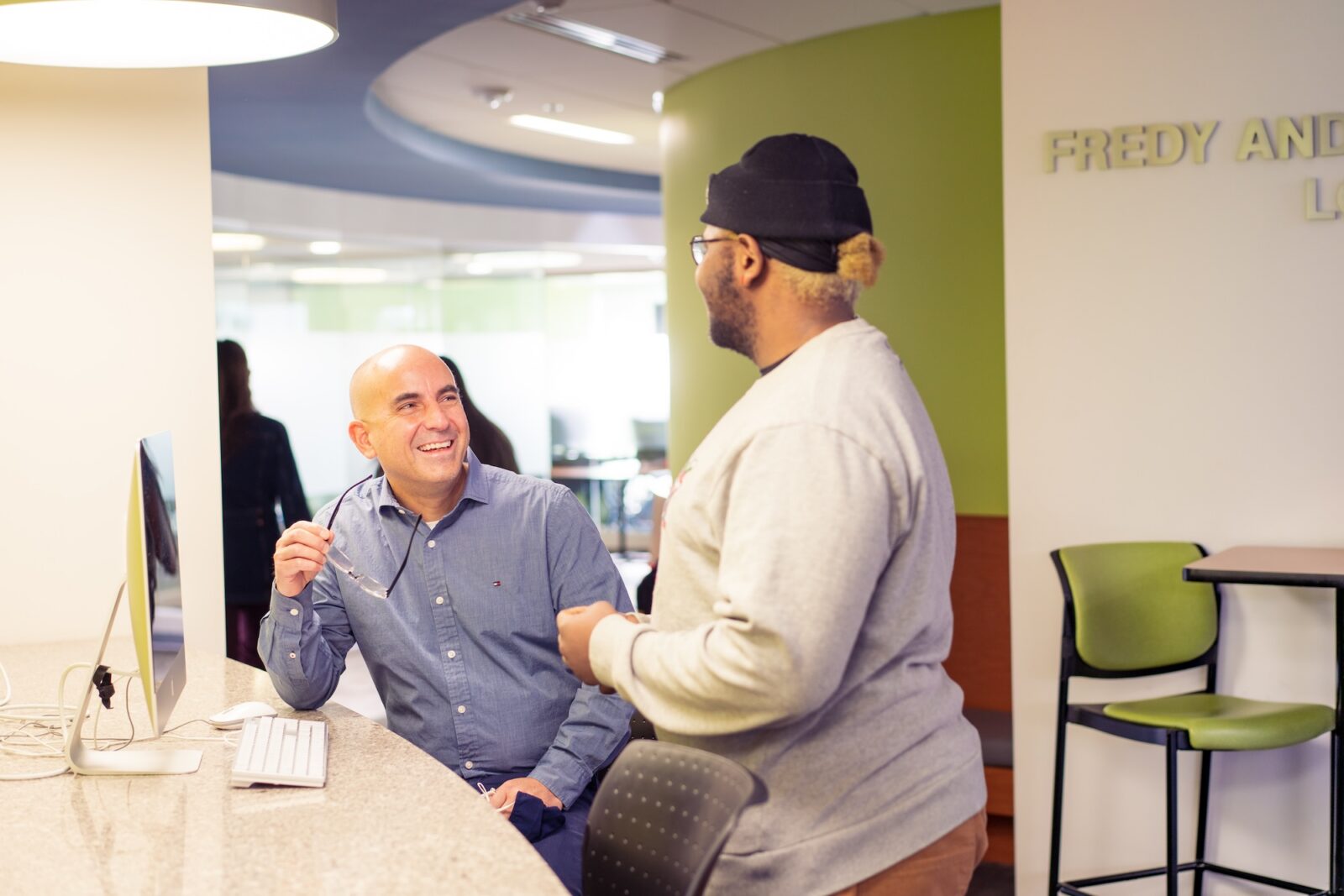 an advisor talking with a student in a brightly lit academic area