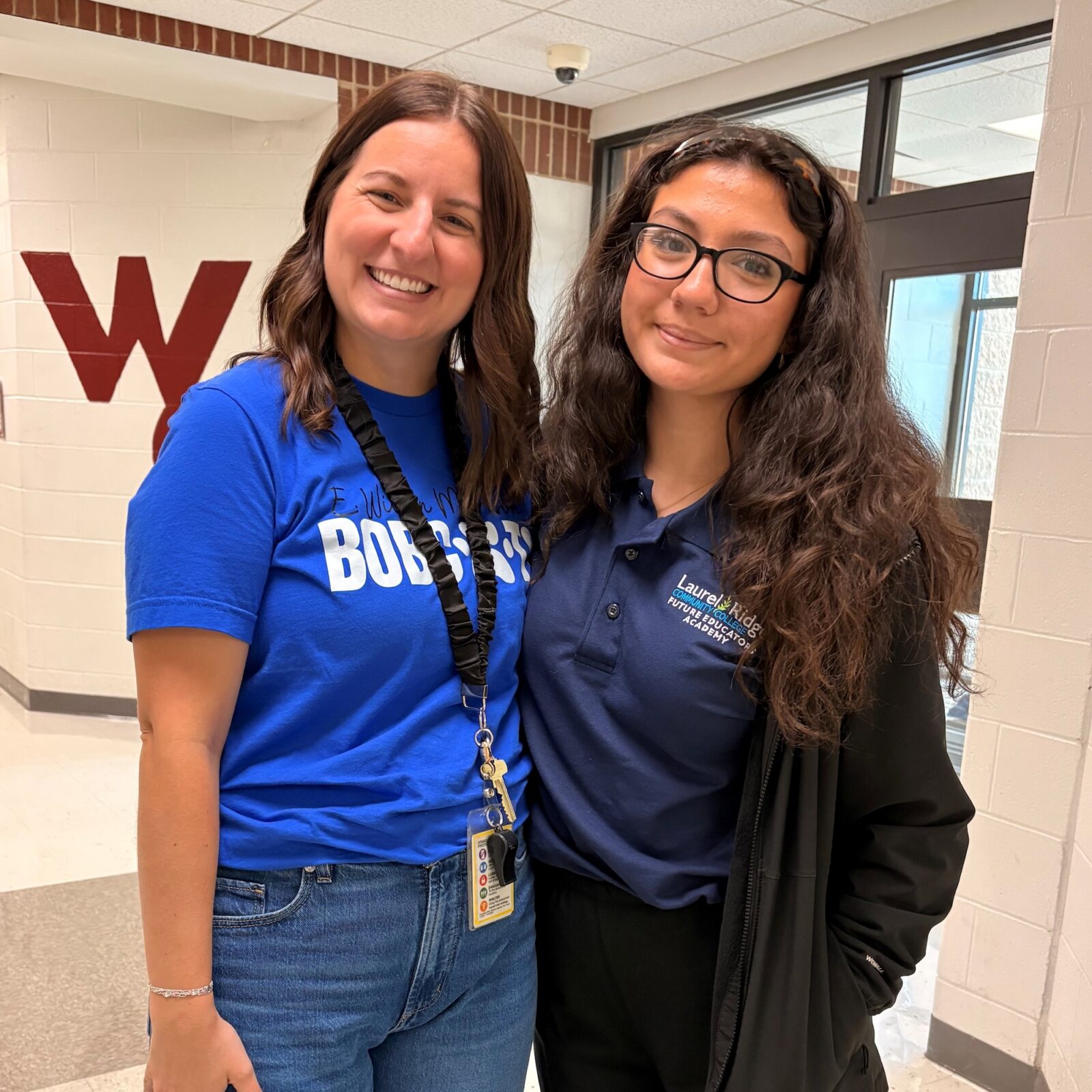 Ms. Brooke Ache, Third Grade Teacher at E. Wilson Morrison Elementary School standing in hallway with FEA junior, Keanna.